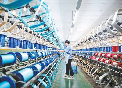 9月12日,工人在重庆市黔江区的丝绸生产车间络丝.